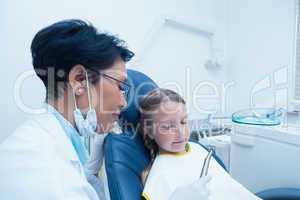 Female dentist examining girls teeth