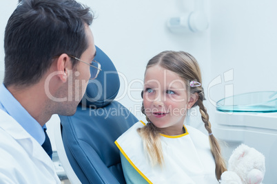 Male dentist examining girls teeth