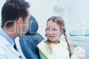 Male dentist examining girls teeth