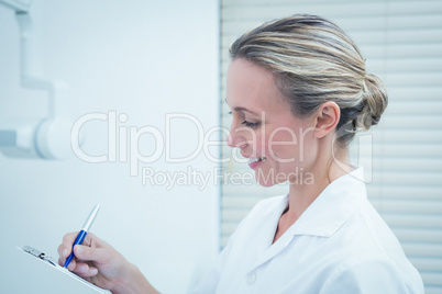 Female dentist checking reports