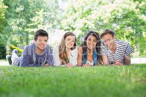 Happy students using laptop outside