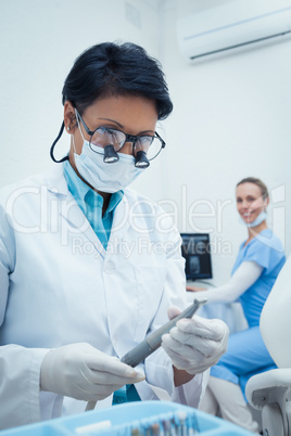 Concentrated dentist looking at dental tool