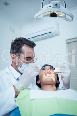 Male dentist examining womans teeth