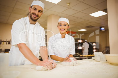 Team of bakers kneading dough