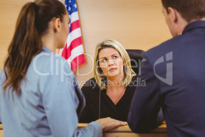 Judge and lawyers speaking in front of the american flag