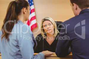 Judge and lawyers speaking in front of the american flag