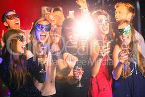Friends in masquerade masks drinking champagne
