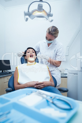 Female dentist examining womans teeth