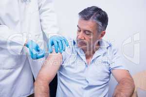 Doctor giving injection to his patient