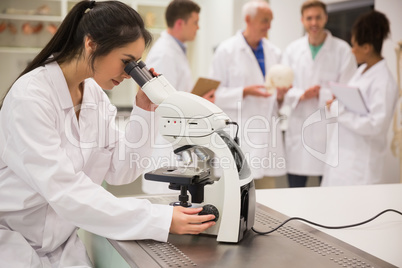 Young medical student working with microscope