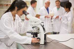 Young medical student working with microscope