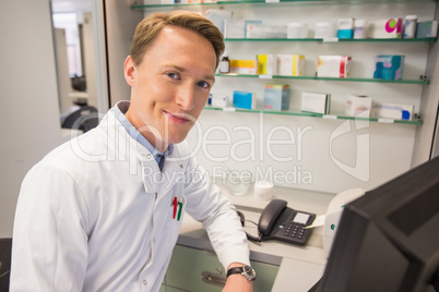 Happy pharmacist using the computer