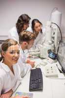 Biochemistry students using large microscope and computer