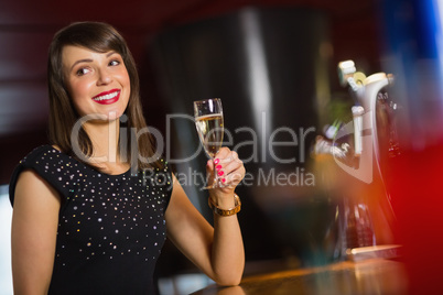 Pretty brunette drinking glass of champagne