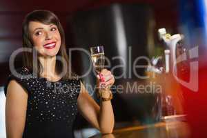 Pretty brunette drinking glass of champagne
