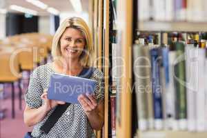 Mature student studying in the library with tablet