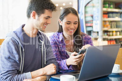 Young students doing assignment on laptop together