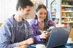 Young students doing assignment on laptop together