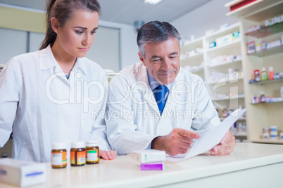 Pharmacist showing a prescription to his trainee
