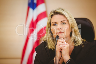 Portrait of a serious judge with american flag behind her