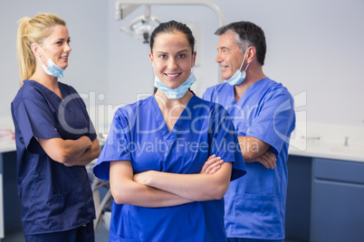 Smiling co-workers talking with arms crossed