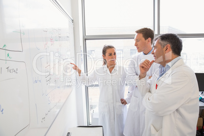 Science students and lecturer looking at whiteboard