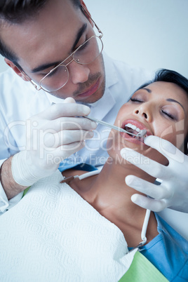 Male dentist examining womans teeth