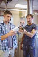 Two casual men testing beer in the beaker