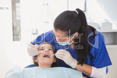 Pediatric dentist using dental explorer and angled mirror