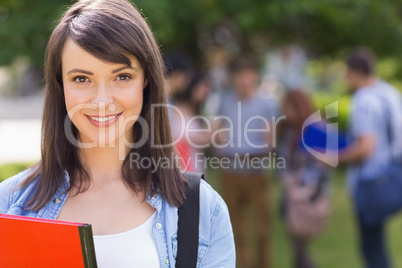 Pretty student smiling at camera outside on campus