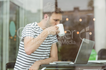 Smiling student drinking hot drink