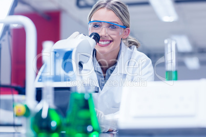 Happy science student working with microscope in the lab