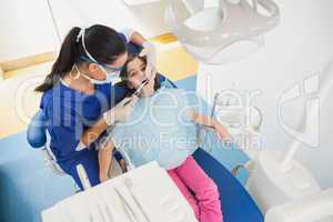 High angle view of pediatric dentist examining her young patient