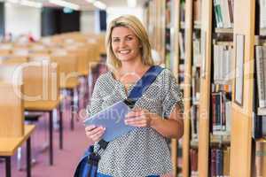 Mature student studying in the library with tablet