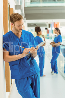 Medical student taking notes in hallway