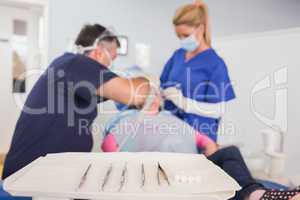 Dentist and his dental assistant examining a young patient