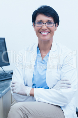 Smiling female dentist with arms crossed