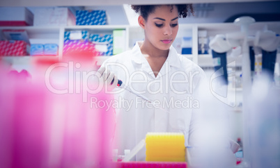 Pretty science student using pipette