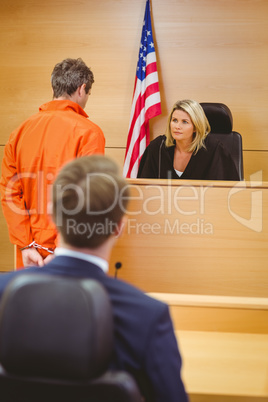 Judge and criminal speaking in front of the american flag