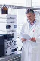 Scientist standing in lab coat reading analysis