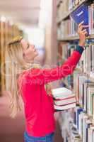 Mature student picking out book in library