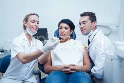 Dentists showing woman prosthesis teeth