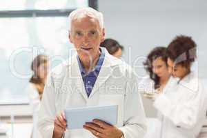 Science lecturer holding tablet pc in lab
