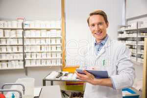 Happy pharmacist using tablet pc