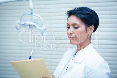 Female dentist reading reports