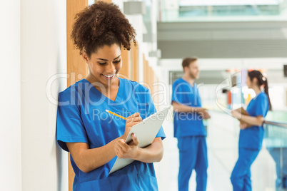 Medical student taking notes in hallway