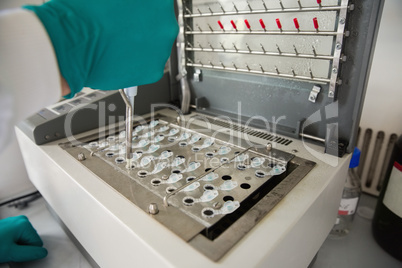 Young scientist using a pipette in chamber