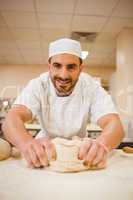 Baker kneading dough at a counter