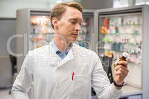 Handsome pharmacist looking at medicine