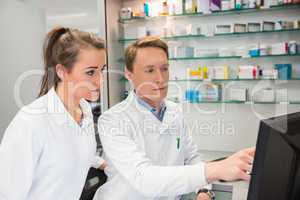 Team of pharmacists looking at computer